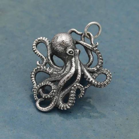 The Nina Designs Detailed Octopus Charm Silver features textured, regenerative tentacles and a polished finish, shown against a blue background.