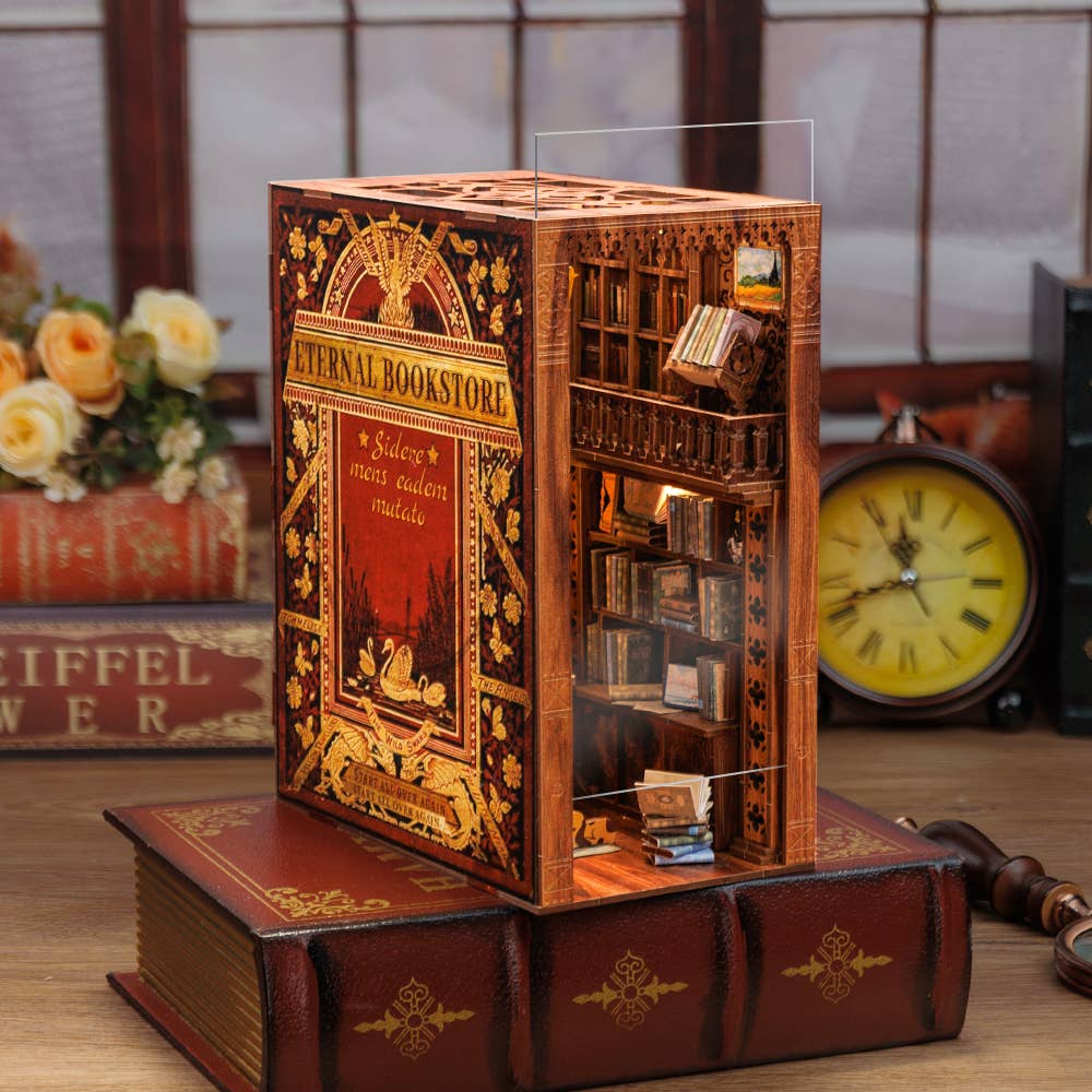 The Hands Craft DIY Book Nook Kit: Eternal Bookstore with Dust Cover features shelves, tiny books, and warm LEDs for a cozy bookstore scene between your books—an ideal literary gift for book lovers.