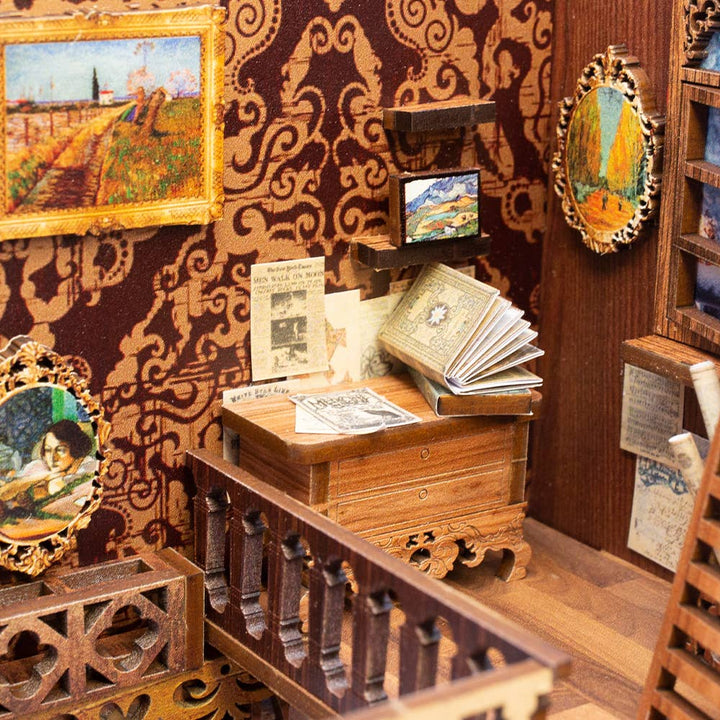 The Hands Craft DIY Book Nook Kit: Eternal Bookstore with Dust Cover features a vintage study room with ornate wallpaper, framed art, a wooden desk with books and papers, plus a decorative banister—a perfect literary gift.