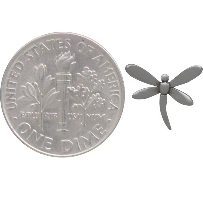 A pair of Silver Dragonfly Post Earrings by Nina Designs, crafted in sterling silver, rests beside a U.S. dime for size comparison. The dime's torch and branches are encircled by "United States of America" and "One Dime," emphasizing the delicate craftsmanship of each dragonfly earring.