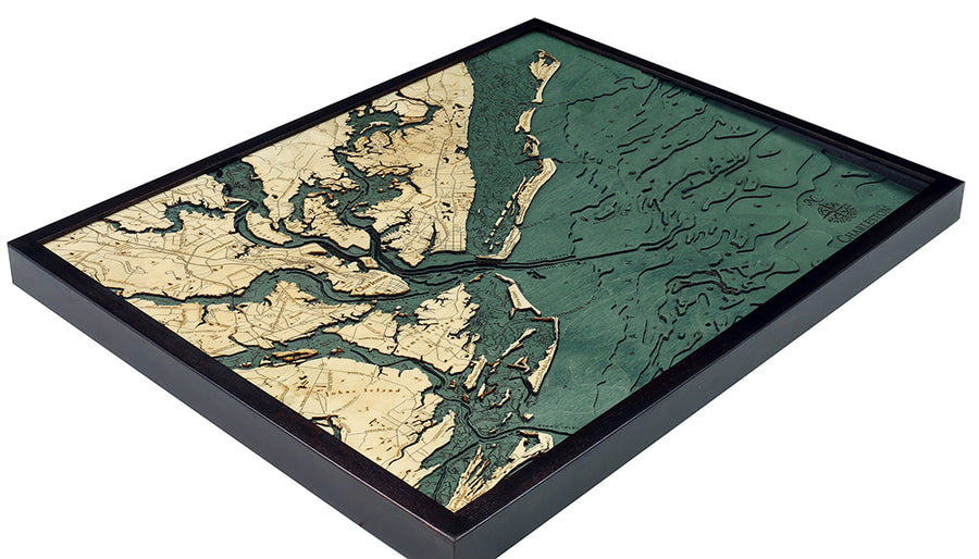 The WoodChart CharlstonSC 24.5 x 31 Black Frame is a framed, 3D layered wooden map in beige and green, displaying detailed land contours and waterways with a textured surface.