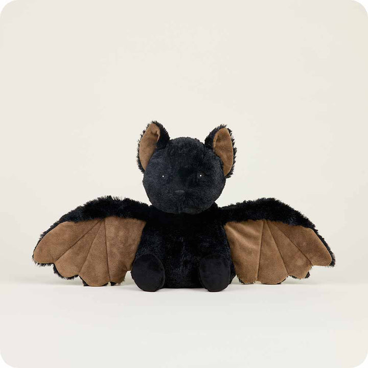 A Bat Warmie, crafted by Warmies, features soft black fur and brown wings as it sits upright against a plain white background. Its wings are outstretched, with small pointed ears and shiny eyes completing the plush toy's design.