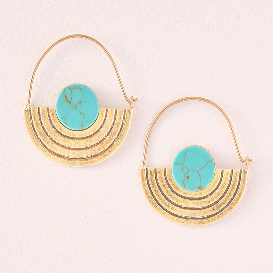 The Stone Orbit Earring Turquoise Gold by Scout Jewelry features hypoallergenic designs with crescent-shaped textures crafted from 14K gold dipped brass. Each earring is adorned with a vibrant turquoise circular stone at the top, and delicate thin gold hoops elegantly connect the crescents, all set against a light background.