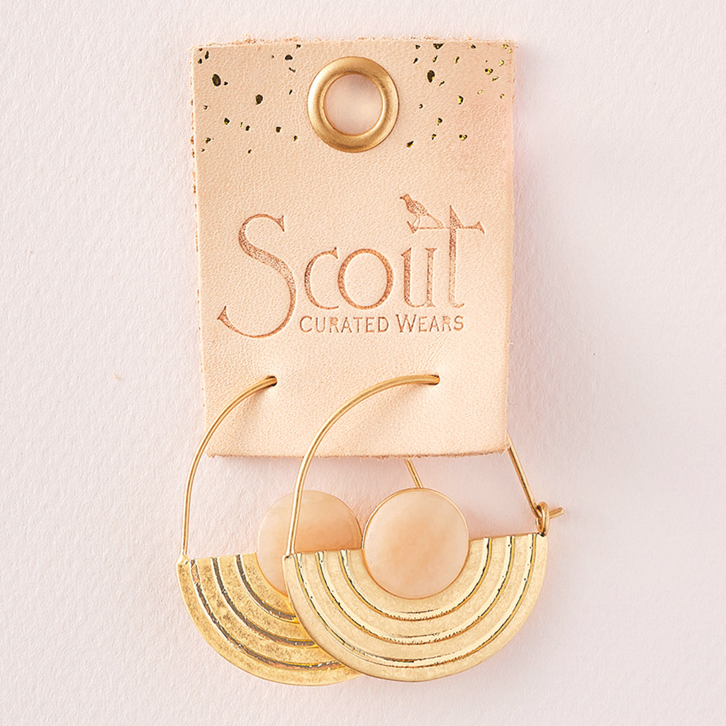 A pair of Stone Orbit Earring Sunstone Gold from Scout Jewelry, featuring pink sunstone accents and arc detailing, presented on a pink backing card with the text "Scout Curated Wears.