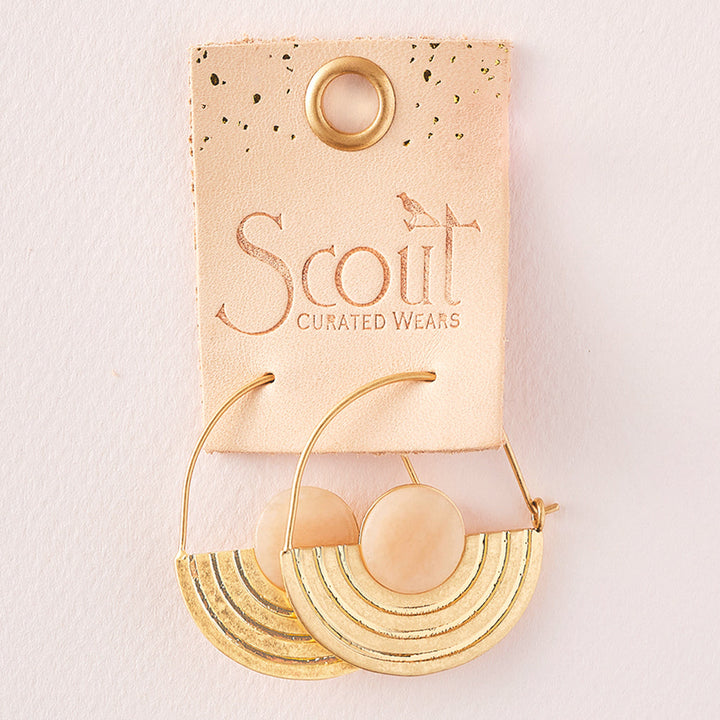 A pair of Stone Orbit Earring Sunstone Gold from Scout Jewelry, featuring pink sunstone accents and arc detailing, presented on a pink backing card with the text "Scout Curated Wears.