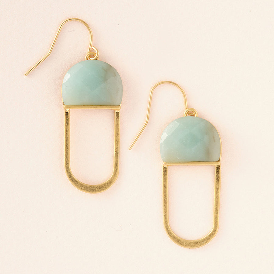 Scout Jewelry's Modern Stone Earring Amazonite features a minimalist pair of hypoallergenic earrings with semi-circle pastel green Amazonite stones at the top, connected to a 14K gold dipped oval-shaped outline. These delicate earrings include gold hooks for comfortable wearing and are displayed on a light beige background.