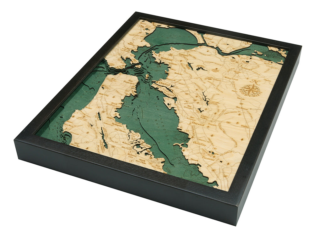 The WoodChart San Francisco Bay 16" x 20" Black Frame is a layered 3D wood map showing the Bay Area with light wood land, teal water, engraved geographic details, and a compass rose for a nautical look.