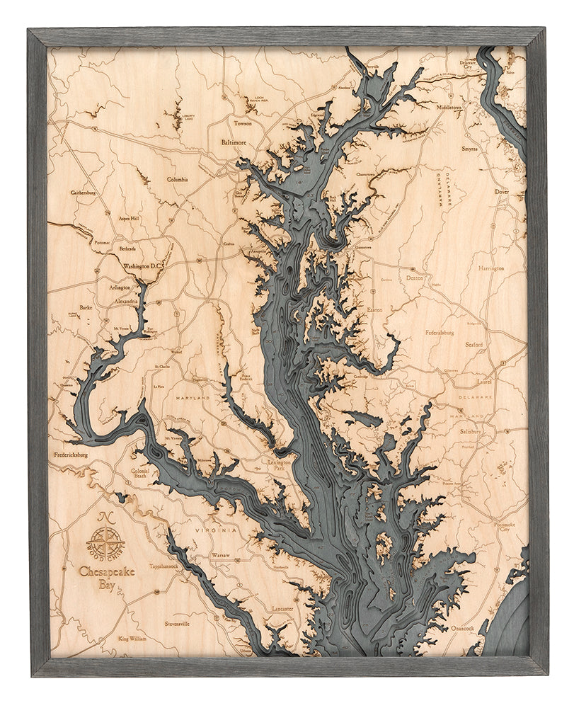 The WoodChart Chesapeake Bay 24.5" x 31" Grey Frame map features detailed engravings of waterways, land, and labeled towns, with the bay and rivers in a contrasting darker wood tone.