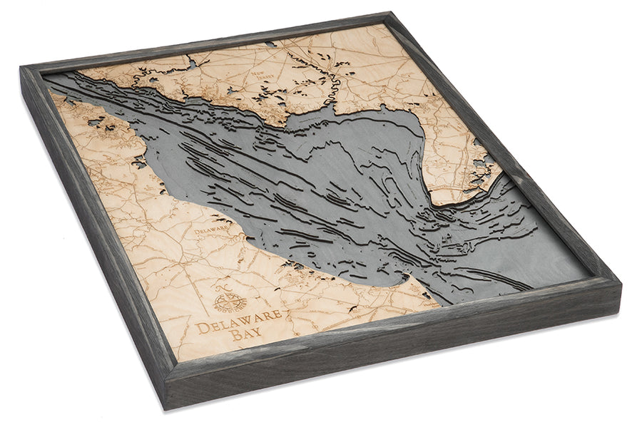 The WoodChart Delaware Bay 24.5 x 31 Grey Frame is a framed, layered wooden map featuring engraved geographic details of Delaware Bay and its surroundings, highlighted by light wood and gray accents, shown from a slight angle.