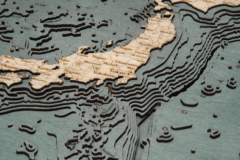 The WoodChart Japan Korea 16" x 20" Grey Frame features a detailed, layered wooden map highlighting Japan and nearby waters, with major cities like Tokyo and Yokohama labeled using raised layers for land and underwater topography.