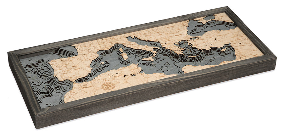 The WoodChart Mediterranean Sea 13.5" x 31" Grey Frame is a layered wooden topographic map with natural wood and dark gray tones, showing land elevation and water depth of the Mediterranean Sea region.