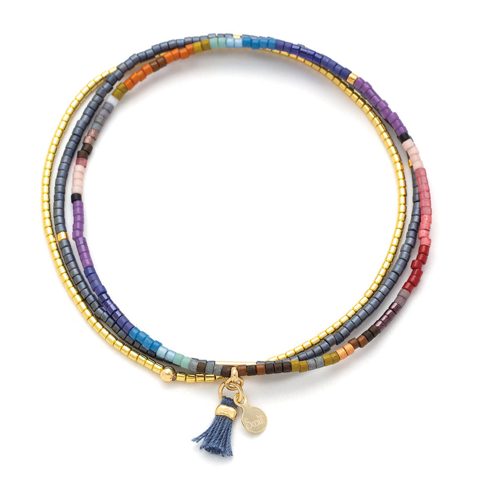 Introducing the Dark Multi Gold Miyuki Bracelet Trio by Scout Jewelry: This vibrant set features exquisitely crafted bracelets made with small square Miyuki Delica beads in shades of blue, purple, pink, and gold. Each bracelet is accented with a 14K gold charm and a blue tassel, making them perfect for stacking to enhance any ensemble.