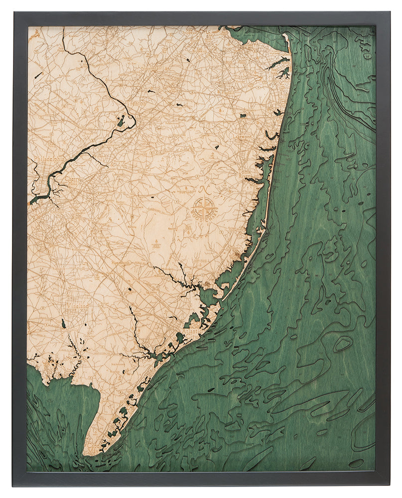 The WoodChart NJ Full Shore 24.5 x 31 Black Frame features a wooden map of southern New Jersey’s coast, with tan land marked by engraved roads and green water with detailed contours, all set in a sleek black frame.