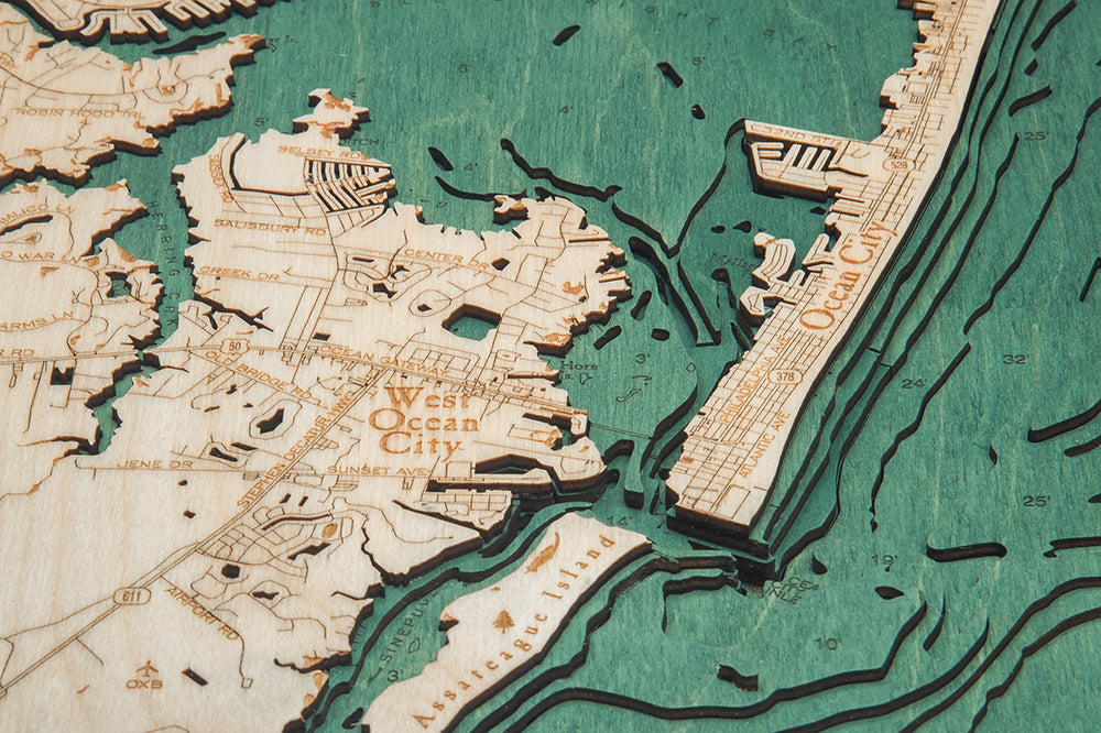 The WoodChart NJ Full Shore 24.5 x 31 Black Frame features an engraved wooden map of the New Jersey shore, with labeled towns, streets, and water features highlighted on a textured green-blue background.