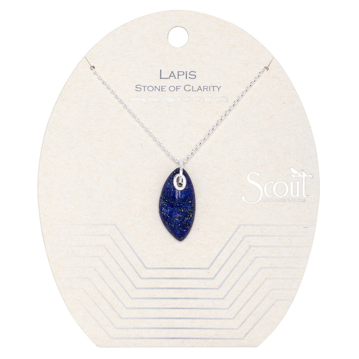 The "Lapis Silver Organic Stone Necklace" from Scout Jewelry features an elegant oval-shaped lapis stone pendant on a silver chain. It includes an adjustable chain for the perfect fit and is presented on a beige card that reads "Lapis Stone of Clarity," with a circular hole at the top and a geometric line design at the bottom.