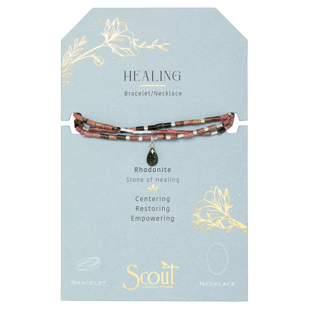 The Scout Jewelry Healing Rhodonite Teardrop Wrap features a multicolored design with semi-precious rhodonite stone beads and a teardrop pendant. The packaging card reads "HEALING," emphasizing rhodonite's properties of centering, restoring, and empowering.