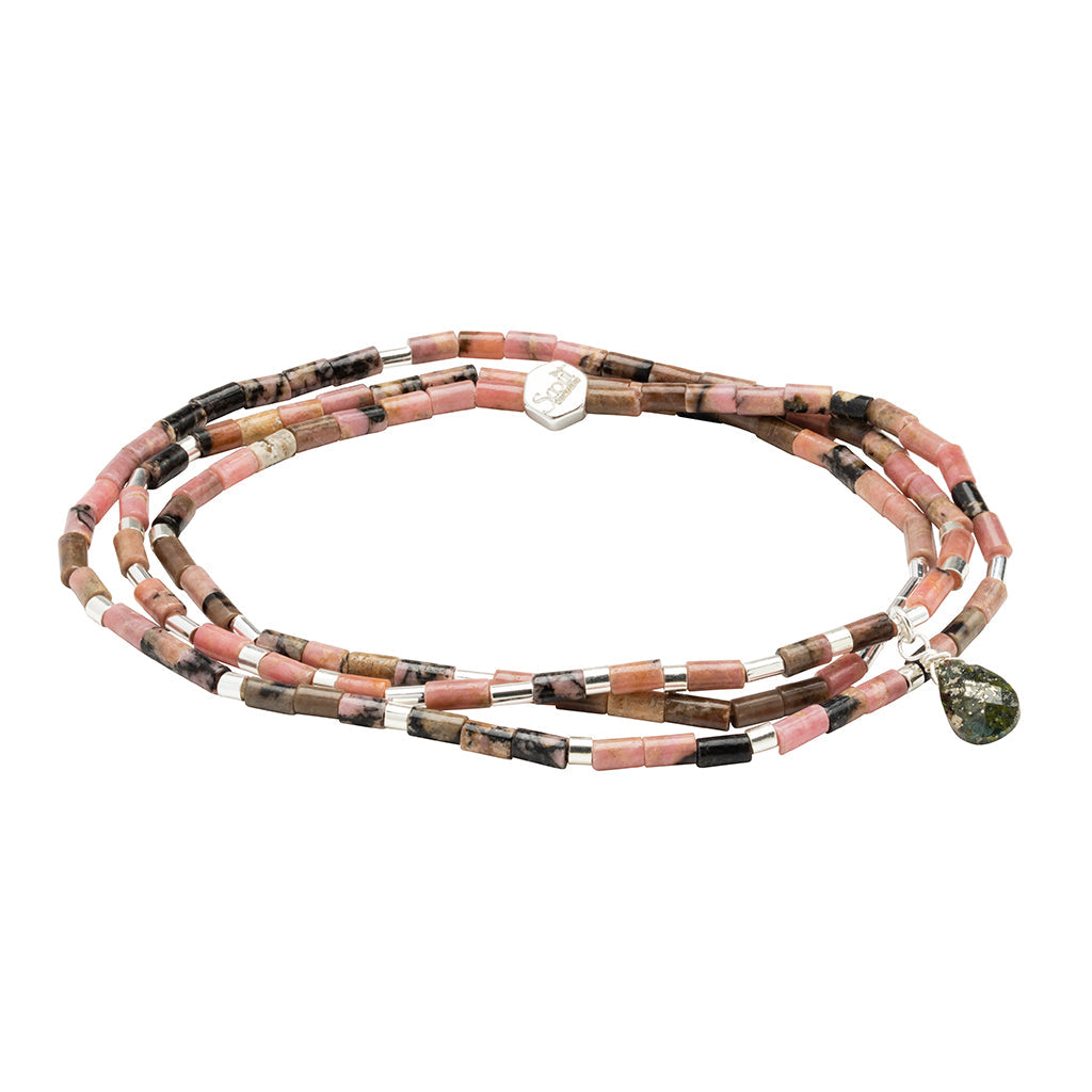 The Healing Rhodonite Teardrop Wrap by Scout Jewelry is a multicolored beaded bracelet featuring semi-precious stone beads in pink, black, and brown shades. It includes a small silver tag and a sparkling green pyrite teardrop pendant.