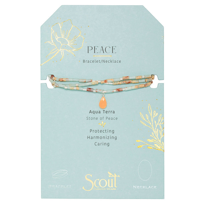 A product display card for the "Peace Aqua Terra Silver Teardrop Wrap" by Scout Jewelry. The card is light green with a floral design and gold accents. The text highlights "Aqua Terra - Stone of Peace" and promotes its protective, harmonizing, and caring properties. This multicolored jewelry features semi-precious gemstones.