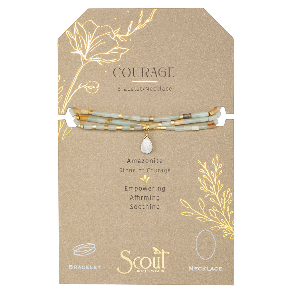 The "Courage Amazonite Gold Teardrop Wrap" by Scout Jewelry is a versatile bracelet/necklace set on a cardboard backer labeled "Courage." This elegant jewelry, featuring semi-precious Amazonite stone beads and a small pendant, is beautifully packaged with floral illustrations and the words: "Amazonite, Stone of Courage, Empowering, Affirming, Soothing.