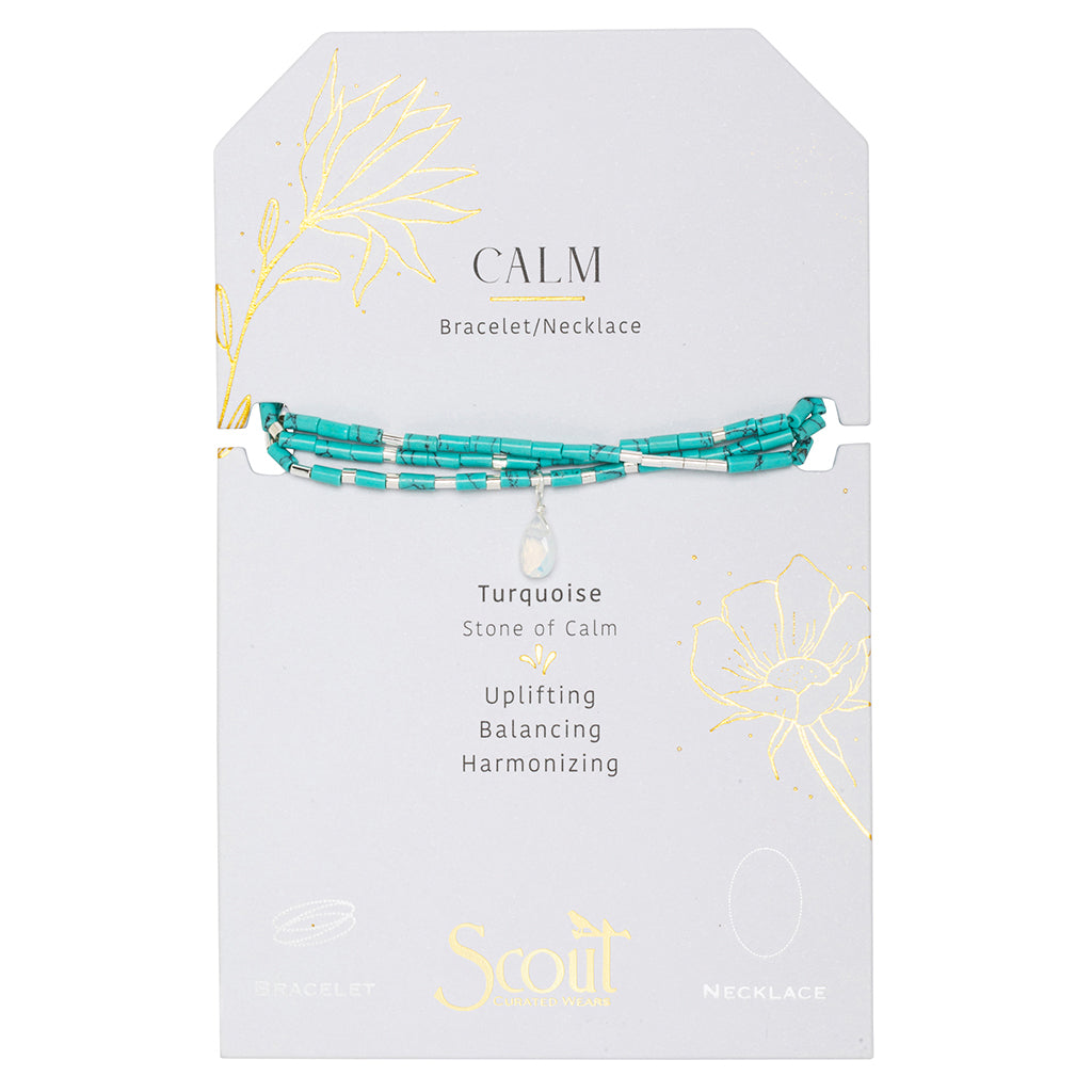 The Scout Jewelry "Calm Turquoise Silver Teardrop Wrap" is an adjustable bracelet/necklace showcasing turquoise beads on a "Calm" card, highlighting their tranquility and harmonizing qualities, with elegant golden floral designs.