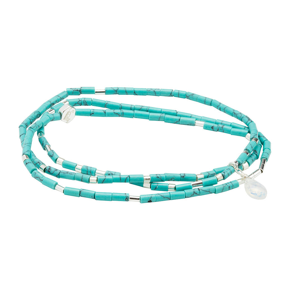 The Calm Turquoise Silver Teardrop Wrap by Scout Jewelry features multi-strand turquoise beads with silver accents and a teardrop pendant, adding elegance and charm.