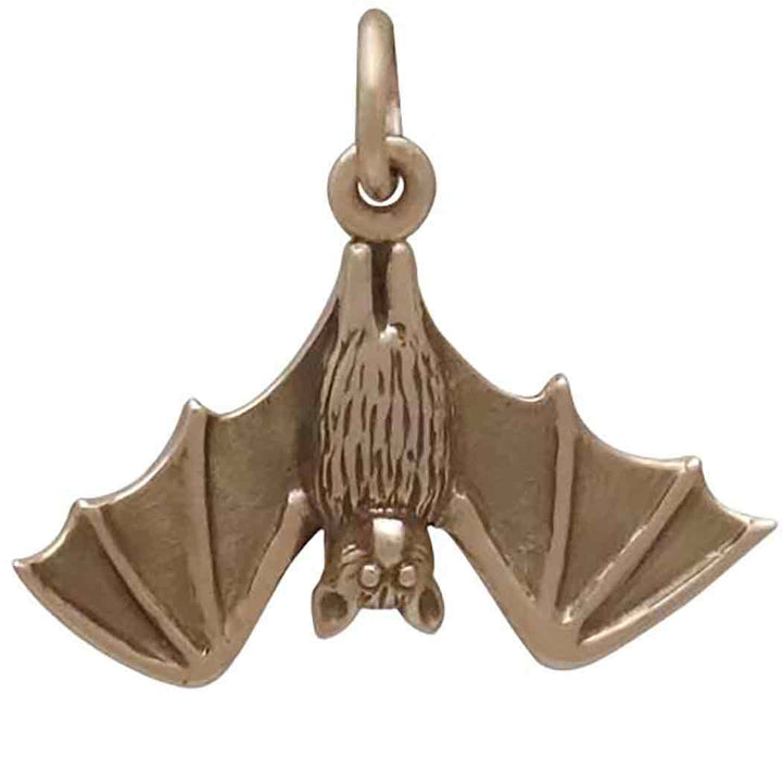 The Bronze Realistic Bat Pendant by Nina Designs showcases a lifelike hanging bat in a gold hue, complete with detailed wings and fur. Symbolizing depth and meaning, the bat hangs upside down from a small loop at the top, making this bronze charm both captivating and significant.