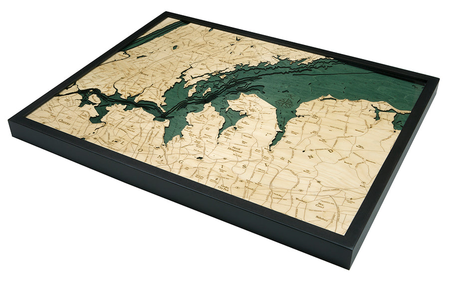 The WoodChart West Long Island 24.5" x 31" Black Frame map features laser-cut, light wood land and dark green water contours, showcasing detailed coastlines and elevation differences in a stylish black frame.