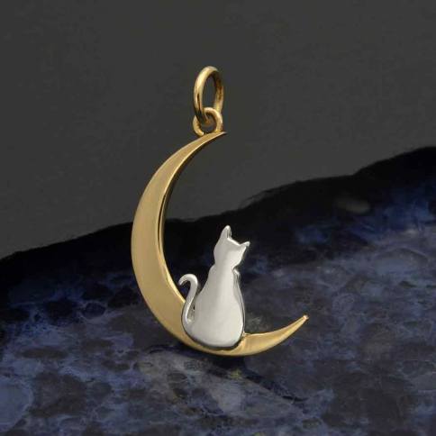 The Moon with Kitty Charm by Nina Designs showcases a sleek sterling silver kitty silhouette gracefully perched on a crescent moon crafted from gold, set against a dark, marbled textured background.