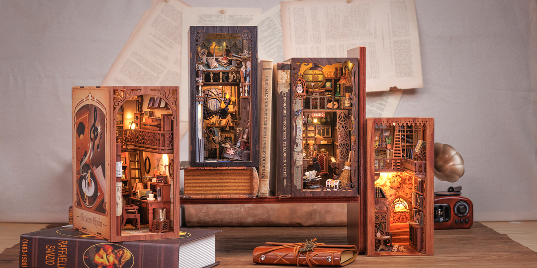 Five intricately designed Hands Craft DIY Book Nook Kits: Eternal Bookstore with Dust Cover are displayed among scattered books and papers, each creating a cozy, detailed mini interior—making an ideal literary gift.
