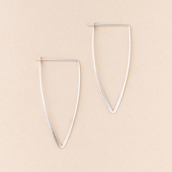 A pair of Galaxy Triangle Silver earrings by Scout Jewelry, made of hypoallergenic and nickel-free sterling silver, are displayed on a light beige background.
