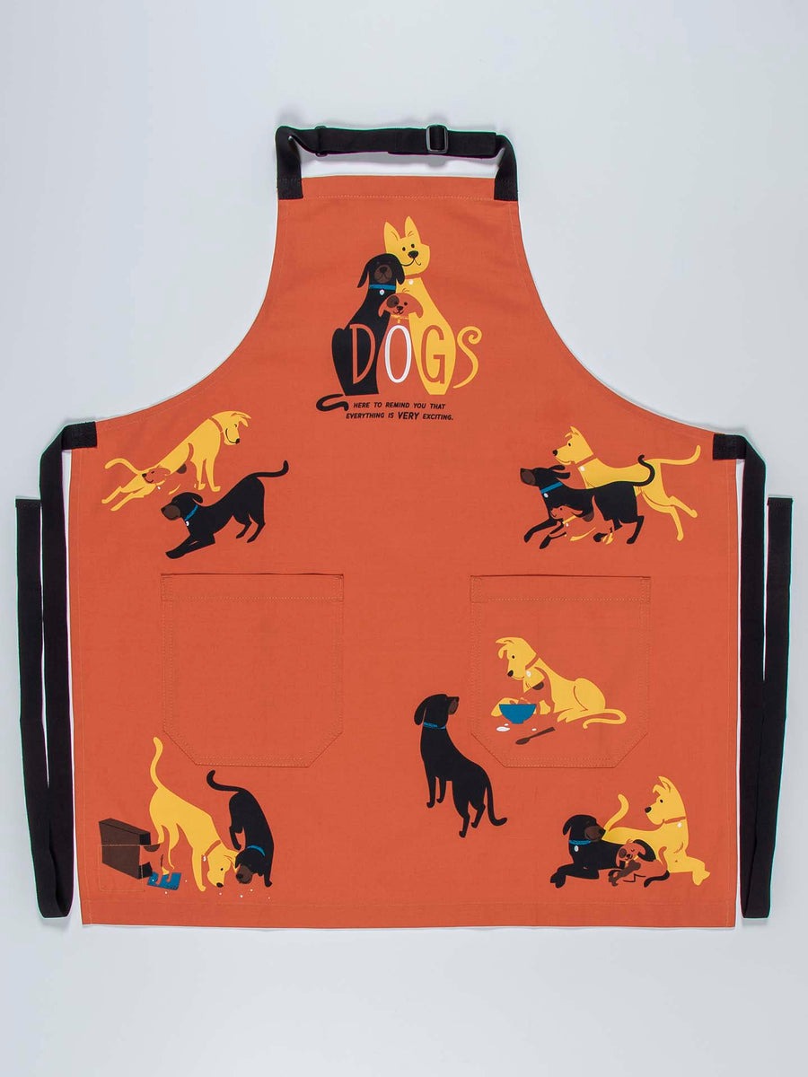 The Blue Q Dogs Apron is a vibrant orange piece crafted from durable heavy cotton twill. It showcases whimsical illustrations of dogs in various poses, including sitting, playing, and interacting with dog bowls. The design prominently features the word "DOGS" amid the charming canine imagery. This apron also includes two front pockets and an easily adjustable neck strap for convenience.