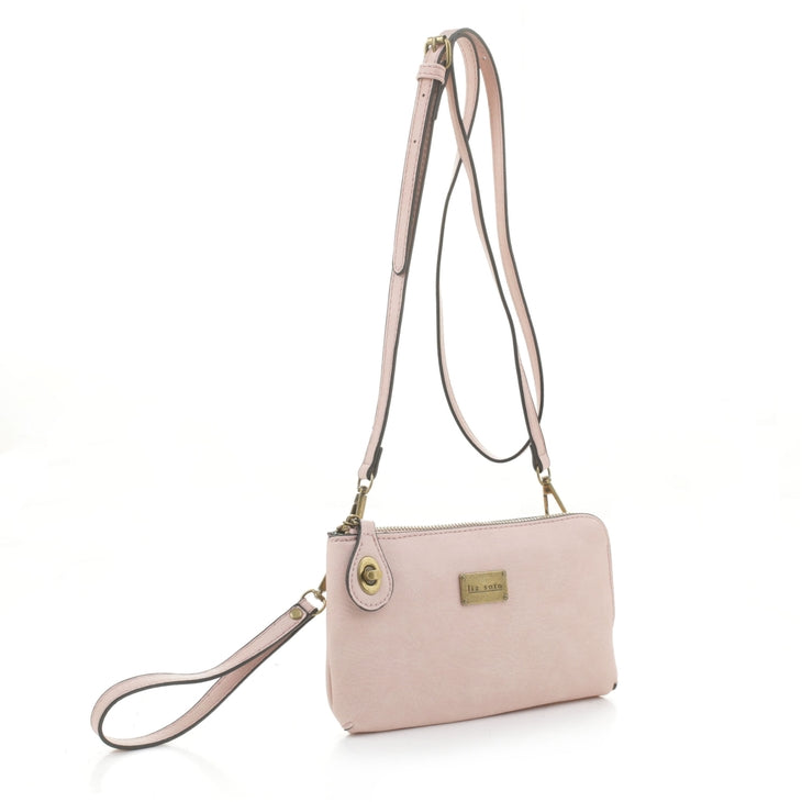 Featuring an elegant, minimalist design, the Tina Cell Bag - Blush by Liz Soto Handbags is a versatile accessory. This light pink wristlet can also be worn as a crossbody bag thanks to its detachable wrist strap and long, narrow adjustable strap. Gold-tone hardware and a branded logo plaque on the front add to its everyday elegance.