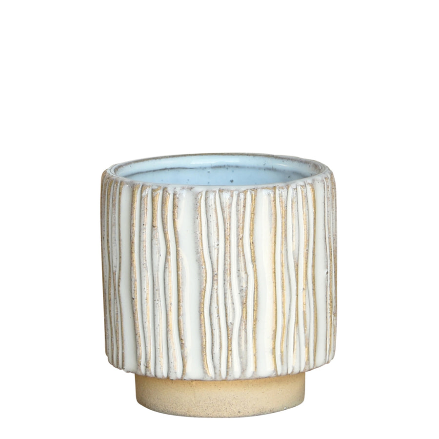 The Vertical Stripe Cachepot by HomArt is a small, cylindrical stoneware pot with a smooth, light beige base and vertical textured ridges. The outer surface showcases a blend of white and tan hues, while the interior is a soft pale blue. Ideal for indoor gardening, it also features a slightly flared opening.