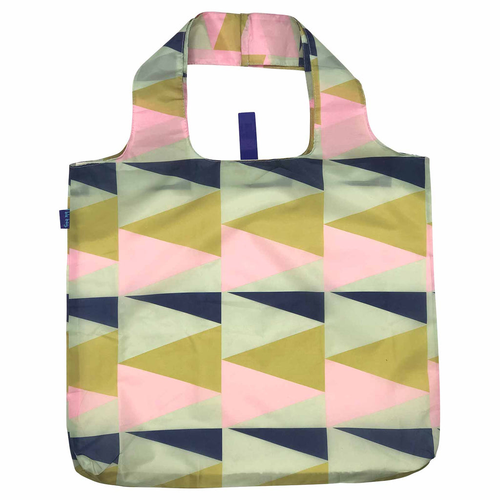 The Zuri Reusable Bag by zzzRockFlowerPaper is both stylish and eco-friendly, featuring a geometric design with overlapping triangles in pink, green, and navy shades. It comes with a convenient handle and has a small blue tag on the side, combining practicality with chic aesthetics.