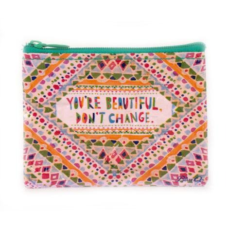 The "You're Beautiful Coin Purse" by Blue Q is a small, colorful pouch featuring a vibrant pattern of dots and triangles in various colors. It has a green zipper and measures 3"h x 4"w. Made from 95% post-consumer recycled material, the text in the center reads, "YOU'RE BEAUTIFUL, DON'T CHANGE," with the brand name "Blue Q" in the bottom right corner. A perfect gift!