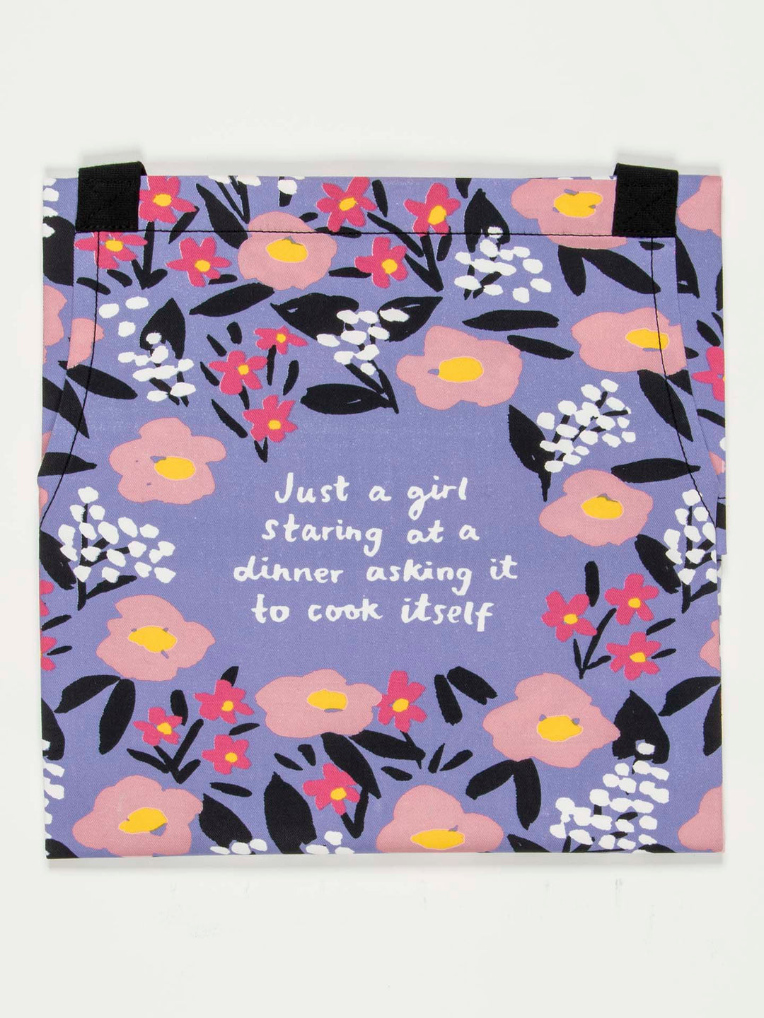 A vibrant oven mitt designed with a floral pattern featuring pink, yellow, and white flowers on a blue background. Crafted from durable cotton twill by Blue Q, it includes the phrase, "Just a girl staring at a dinner asking it to cook itself.