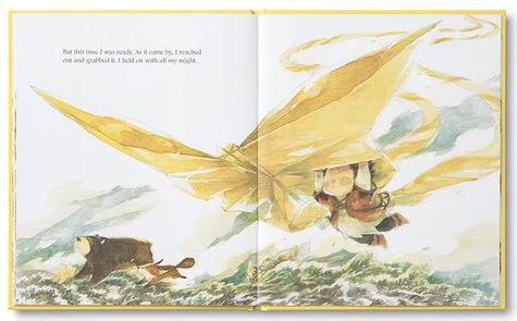 An open illustrated book reveals a person soaring with large yellow wings above rolling green hills and swirling clouds. The text on the left page of Kobi Yamada and Mae Besom's book titled "What Do You Do With a Chance," published by COMPENDIUM, states, "But this time I was ready. As it came by, I reached out and grabbed it.