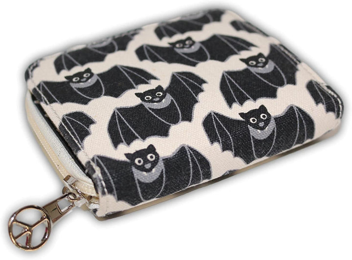 The Bill Fold Wallet Bat by Bungalow 360 is a small square zippered pouch crafted from vegan cotton canvas, featuring a beige background adorned with a pattern of black bats with wide eyes and spread wings. The light-colored zipper is highlighted by a peace sign charm on the pull, adding to its unique design.