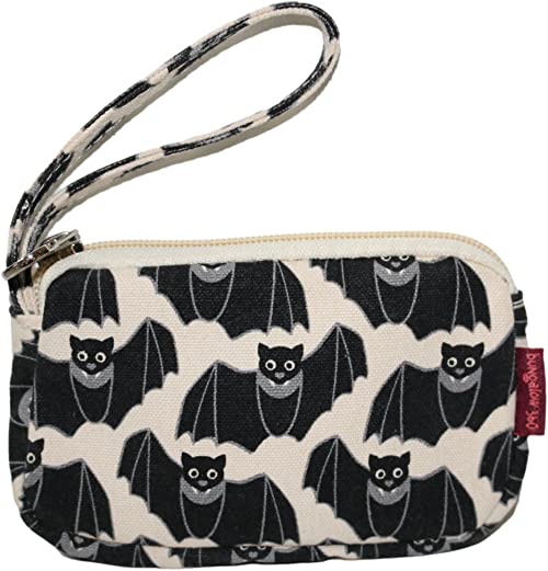 The Tiny Wristlet Bat by Bungalow 360 is a small fabric pouch with a wrist strap, crafted from durable cotton canvas and featuring an all-over black and white print of smiling cartoon bats. It has a zipper closure at the top and showcases unique patterns.