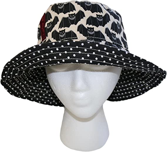 A mannequin head wearing a Bungalow 360 Beach Hat Bat. The crown of the hat showcases unique, one-of-a-kind patterns of bats, while the wide brim is adorned with a white polka dot design on a black background. This reversible beach hat perfectly balances style and function, offering versatility in any setting.