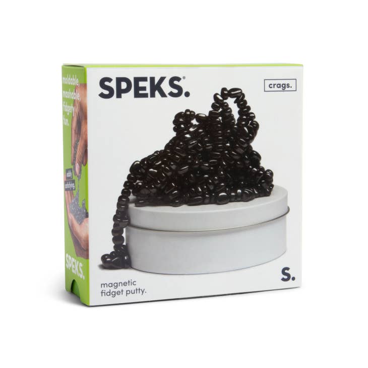 A box of SPEKS Crags Magnetic Putty Stones contains black magnetic beads stacked in a silver tin, providing stress relief and focus. The packaging displays the product name, brand, and highlights the unique magnetic stones for satisfying play.