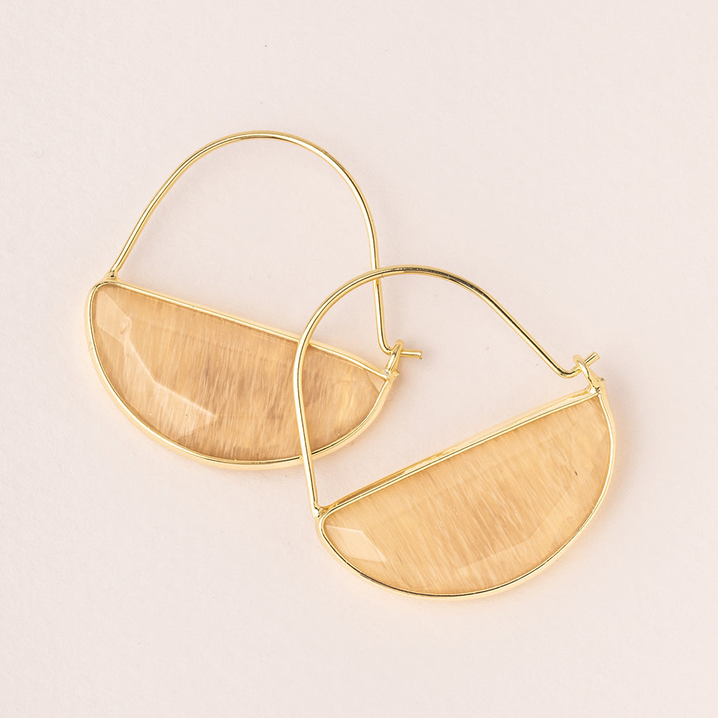 The Hoop Earring Citrine/Gold from Scout Jewelry features a semi-circular design with a beige, wood-like texture. Hypoallergenic and elegant, these minimalist earrings are perfect for sensitive skin, beautifully displayed on a light neutral background.