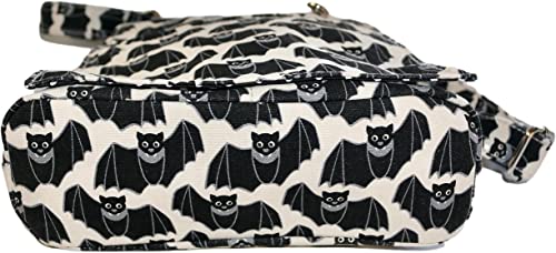 A detailed view of the Sm Messenger Bat by Bungalow 360, crafted from natural and durable cotton canvas. The bag showcases a distinctive pattern of black bats with outstretched wings and smiling faces on a white background. It features a fabric texture and comes with a zippered closure for added functionality.