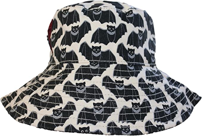 Introducing the Beach Hat Bat by Bungalow 360: a packable wide-brimmed bucket hat adorned with a whimsical and spooky pattern of black bats with white outlines against a beige background. The meticulously crafted stitching details around the brim add both practicality and style, making it the perfect accessory for any outing.