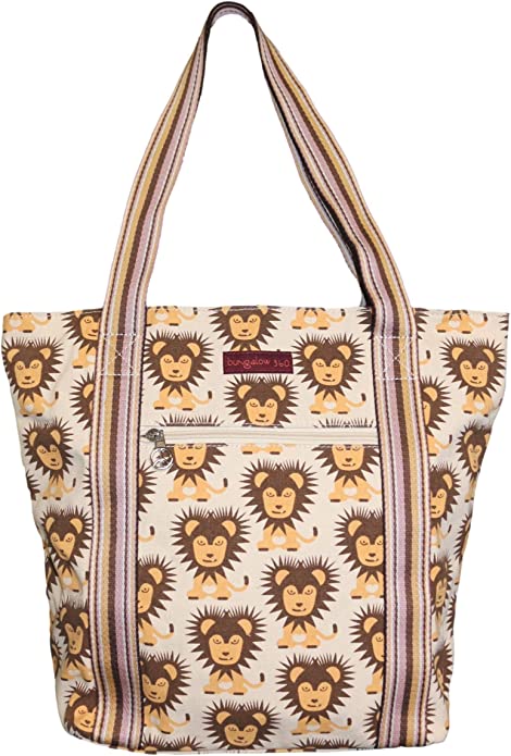 The Bungalow 360 Striped Tote - Lion is a spacious cotton canvas bag in beige, featuring purple and beige striped handles, a front zipper pocket, and a playful print of repeating cartoon lions for everyday style and function.