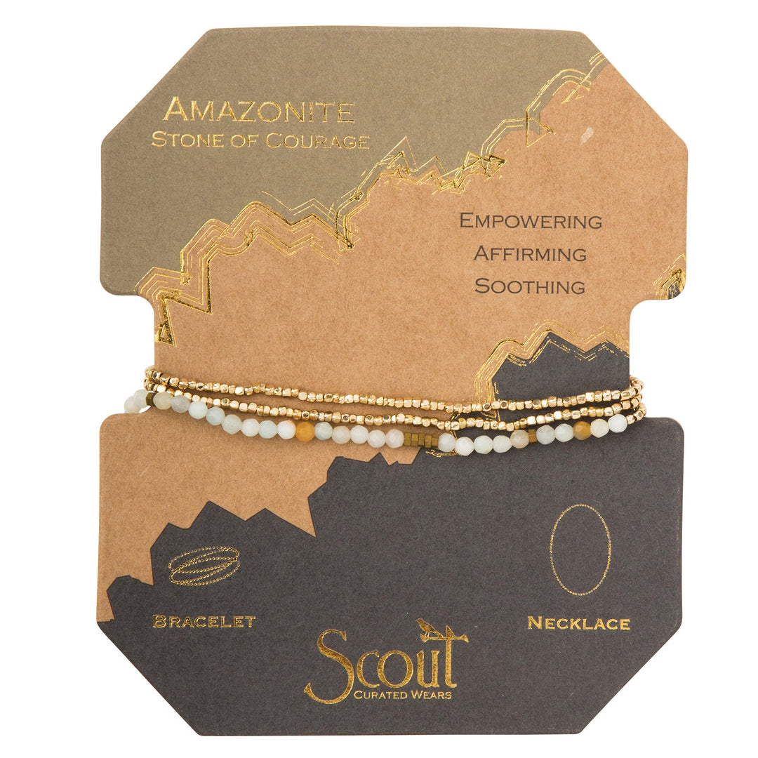 Jewelry packaging with faceted Amazonite Gold Delicate Wrap bracelets, labeled "Amazonite, Stone of Courage." Descriptive words include "Empowering," "Affirming," and "Soothing." The earth-toned packaging highlights the brand “Scout Jewelry.”