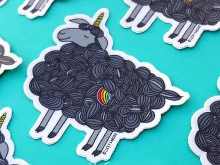 The Black Sheep Unicorn Sticker by Lucky Sardine showcases a black sheep adorned with a vibrant rainbow heart on its wool, set against a teal background. With the addition of a small yellow horn, this sticker is both scratch-resistant and waterproof, guaranteeing enduring vibrancy and durability.