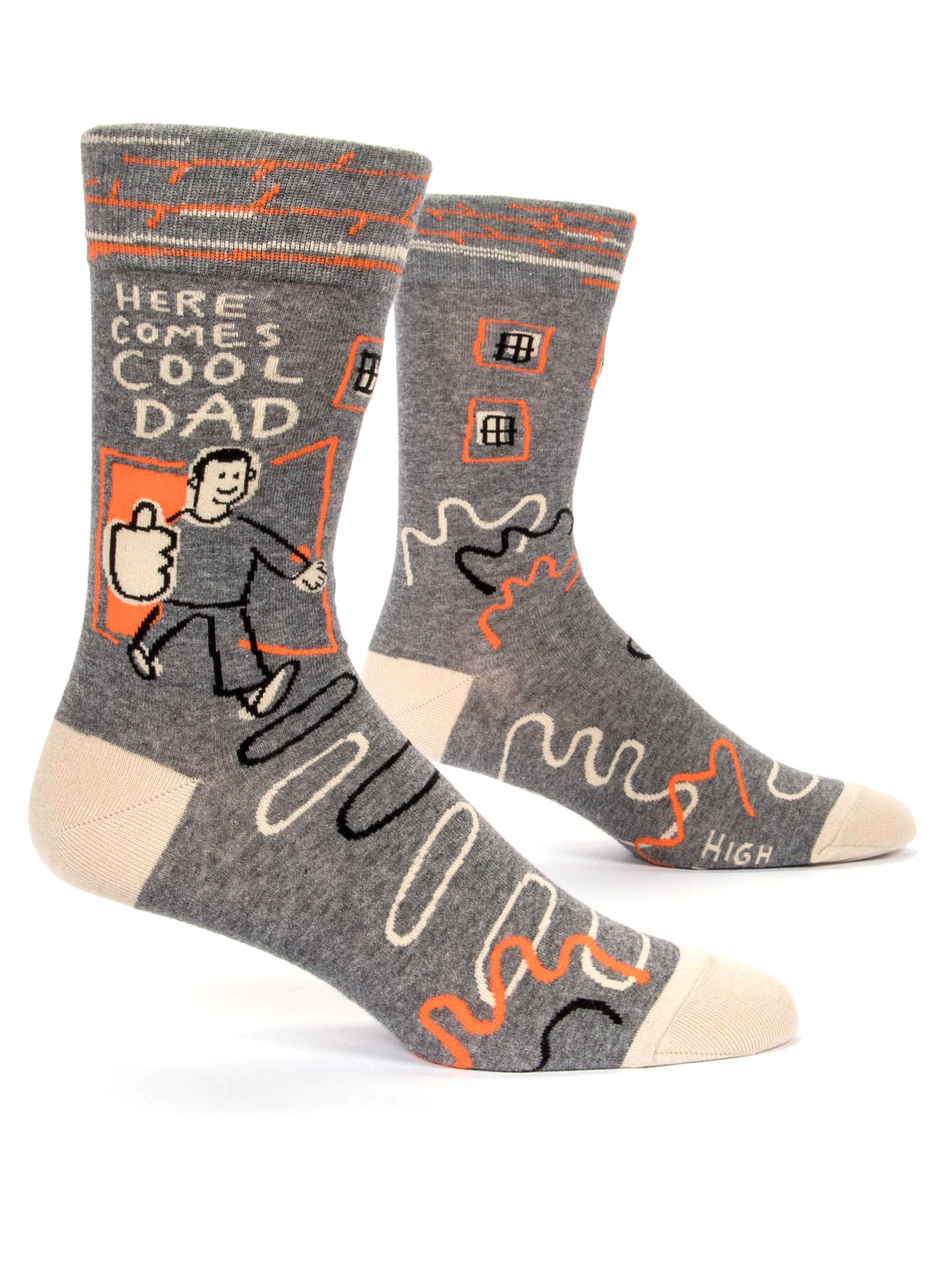 A pair of Here Comes Cool Dad Men's Socks by Blue Q, crafted from combed cotton, comes in gray with beige toes and heels. These socks feature an illustration of a person carrying a briefcase alongside the text "Here Comes Cool Dad." The design also includes playful orange and beige lines along with small window shapes, making them essential footwear for men.