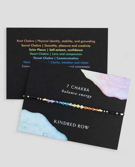 A Chakra Healing Gemstone Stacking Bracelet by Kindred Row is showcased on a card labeled "7 Chakra Balance Energy." This handmade piece, crafted from natural gemstones, features multicolored beads and an adjustable cord. Alongside, another card explains the chakra meanings: root, sacral, solar plexus, heart, throat, third eye, and crown. The background is set in soft pastel tones.