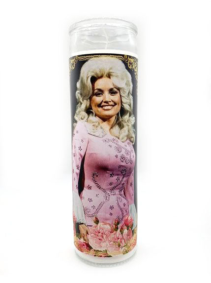 The Dolly Parton Candle by BOBBYK BOUTIQUE showcases a smiling woman in a pink embellished dress and intricate hairstyle, reminiscent of a classic country singer. The base features pink roses on white, making it ideal for any fan's collection.